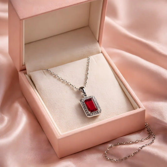 Ogrlica sa svetlucavim crvenim priveskom.